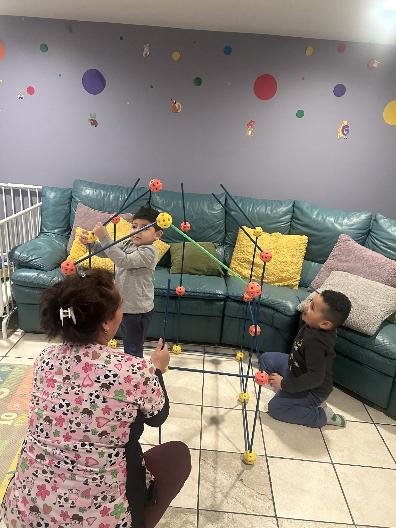 Children exploring a building activity with a caregiver at Miriam Daycare
